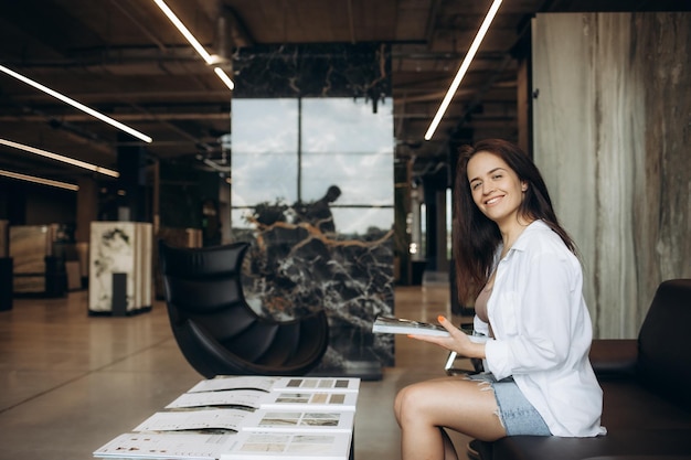 een vrouw kijkt naar een catalogus met goederen in een ijzerhandel