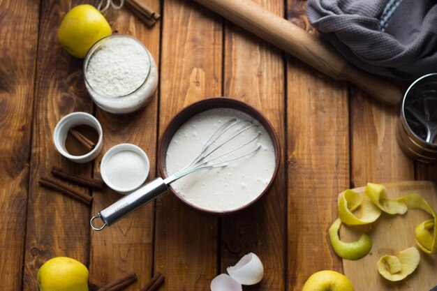 Een vrouw kookt een appeltaart op een houten tafel. Het proces van het maken van een taart.