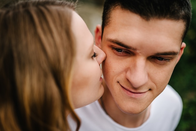 Foto een vrouw kust een man op de wang