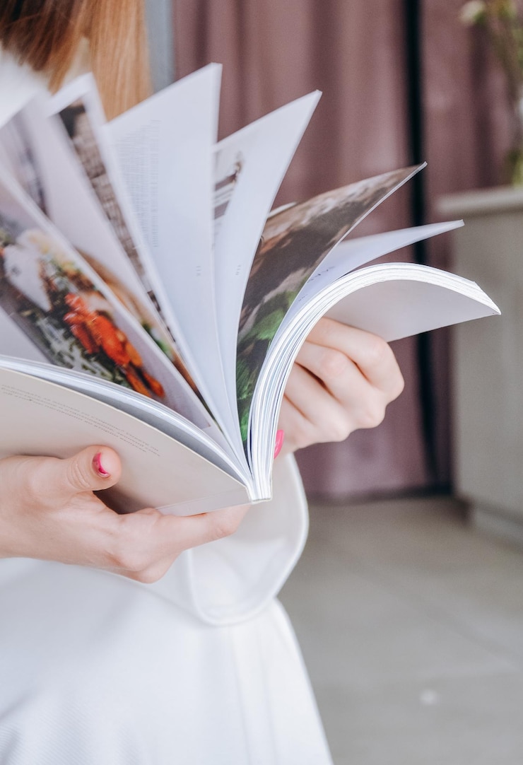 Foto een vrouw leest een boek in een kamer met een roze gordijn.