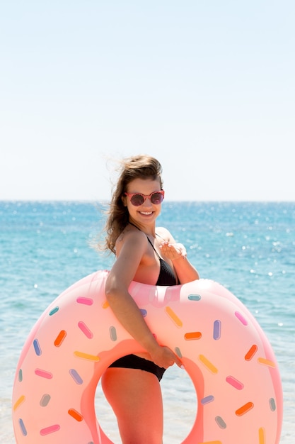 Een vrouw loopt het zeewater in. Meisje ontspannen op opblaasbare ring op het strand. Zomervakantie en vakantie concept.