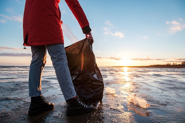 Een vrouw maakt de bank schoon met plastic flessen en stopt het afval in een vuilniszak