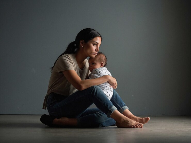 een vrouw met een baby zit met de benen gekruist en een_0