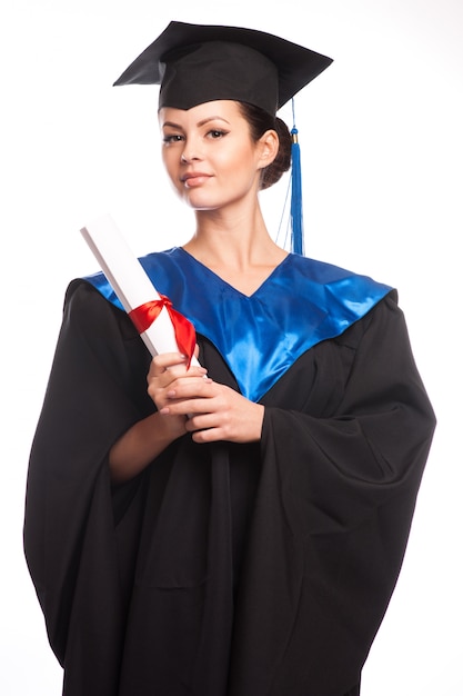 Een vrouw met een diploma in haar hand terwijl ze naar de camera kijkt