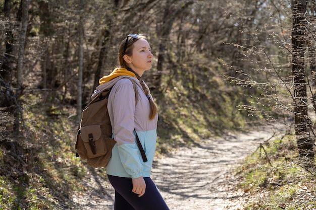 Een vrouw met een grote wandelrugzak in het bos wandelen en reizen