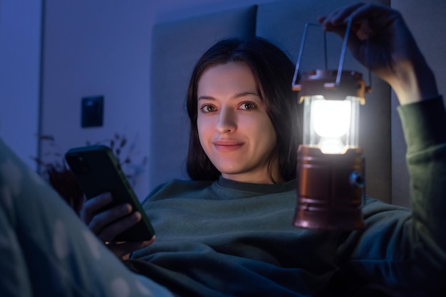 Een vrouw met een lantaarn in haar hand vanwege een black-out in appartement