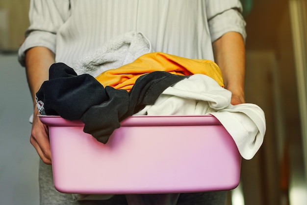 Een vrouw met een mand met vuile was om het huis schoon te maken, thuis routinewerk