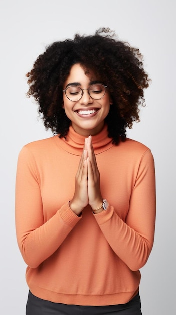 een vrouw met een oranje shirt en bril draagt een oranje trui en glimlacht