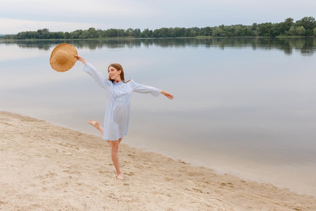 Een vrouw met een strohoed op het strand in de zomervakantie