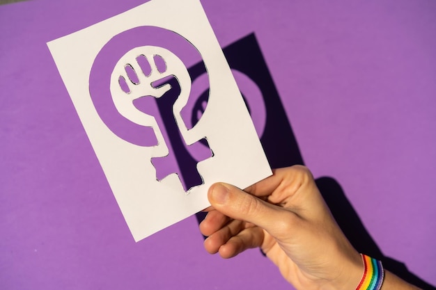 Foto een vrouw met een tekening ten gunste van gelijkheid tussen mannen en vrouwen paarse achtergrond vechtend ten gunste van vrouwen vrouwelijke kracht lgtb-vlag