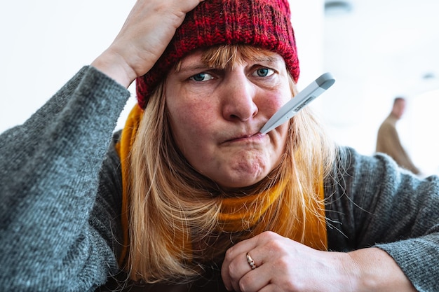 Foto een vrouw met een thermometer in haar mond houdt een thermometer in haar mond.