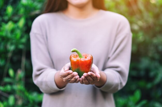 Een vrouw met een verse paprika in de hand