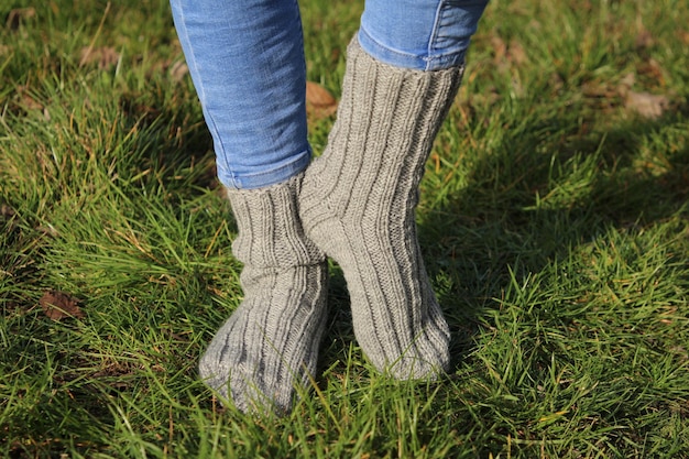 een vrouw met grijze sokken staat op het gras