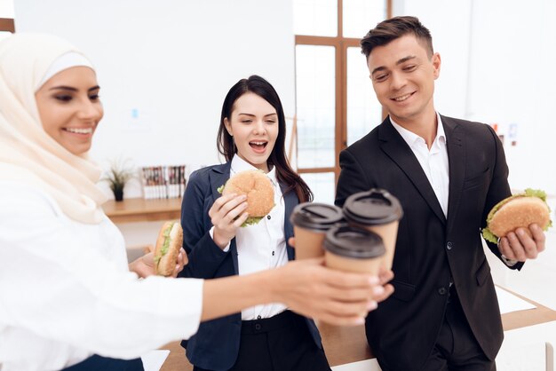 Een vrouw met haar collega&#39;s die een hamburger eten