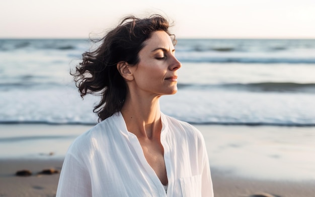 Een vrouw met haar ogen dicht en haar ogen dicht, staande op een strand.