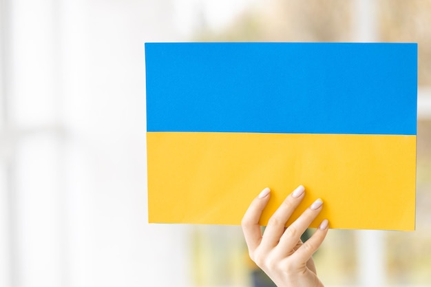 Een vrouw met karton geschilderd in de vlag van Oekraïne