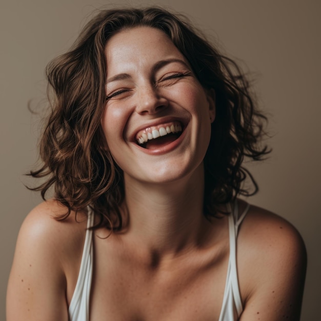 Foto een vrouw met krullend haar die lacht en glimlacht.