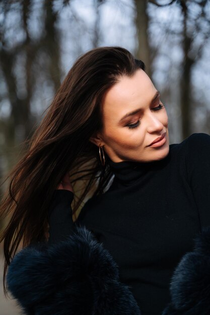 Een vrouw met lang haar die een zwarte jas draagt de elegante vrouw met vloeiende lokken en een stijlvolle zwarte jas