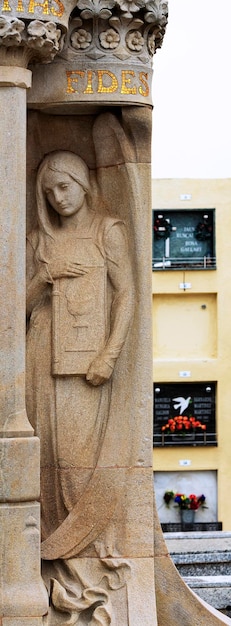 Een vrouw met lang haar en een lange rok staat naast een muur met een bord waarop 7 staat.