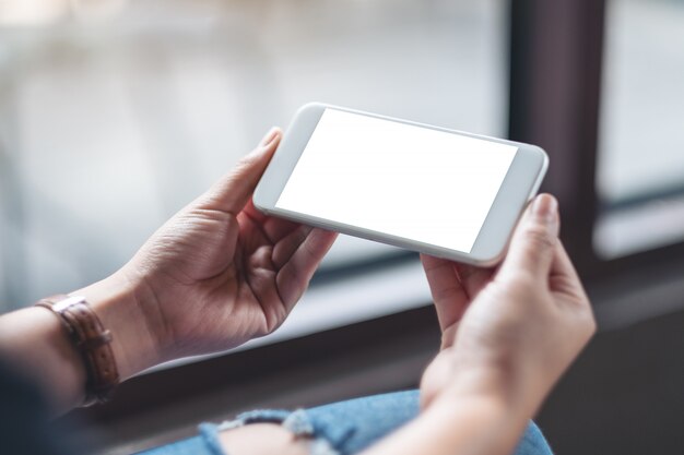 een vrouw met witte mobiele telefoon met lege desktop-scherm in café