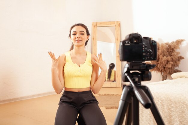 Een vrouw neemt een video op voor haar kanaal op internet. blogger. Emotioneel meisje praat