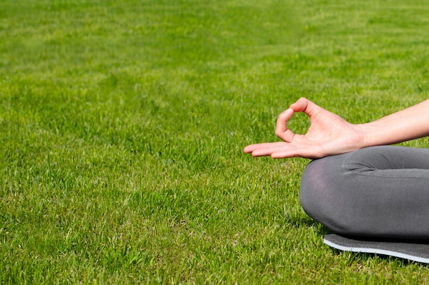 Een vrouw oefent yoga in openlucht op het gras uit. Bental gezondheid, angstvermindering, innerlijke rust