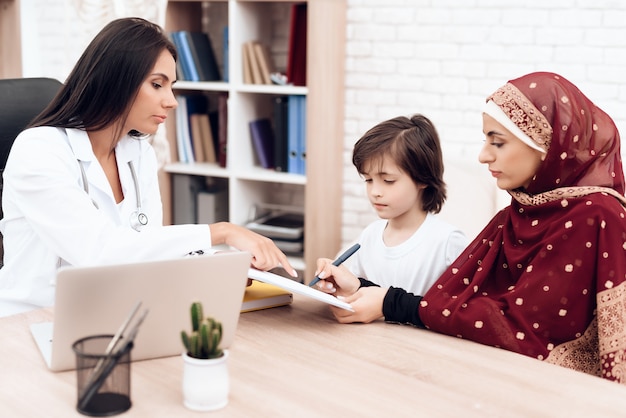 Een vrouw ondertekent documenten in het ziekenhuis.