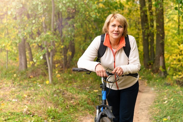 Een vrouw op een fiets rijdt op de weg in het stadspark