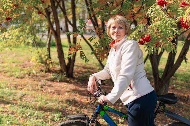 Een vrouw op een fiets rijdt op de weg in het stadspark