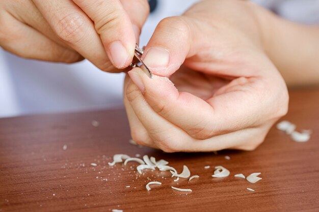 Een vrouw poetst haar nagels met een manicure-tool. Het concept van zorg, schone vingernagels.