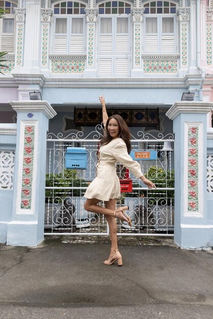 Een vrouw poseert voor een huis waarop staat 'het huis staat te koop'