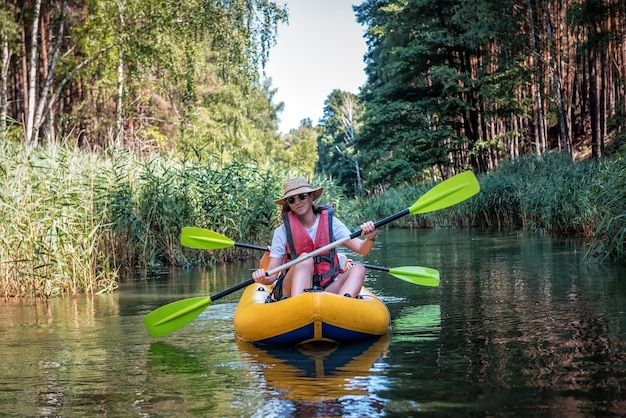 Een vrouw raft op een kajak op een wilde rivier op een zonnige dag