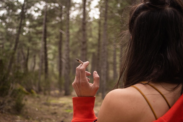 Foto een vrouw rookt in het bos een sigaret te roken