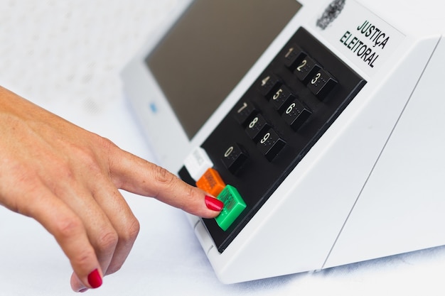 een vrouw simuleert een stem in de elektronische stembus die bij de verkiezingen in Brazilië wordt gebruikt