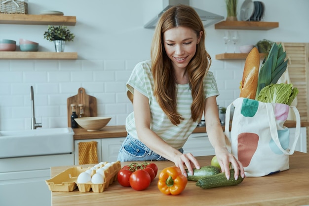 een vrouw snijdt groenten in haar keuken