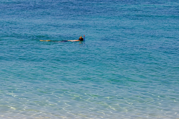 Een vrouw snorkelt voor ondiepe koraalriffen