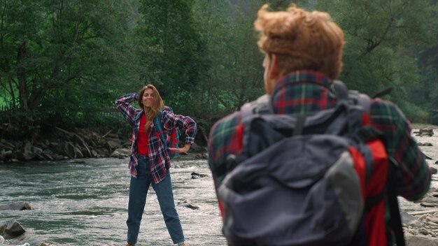Een vrouw staat in een rivier met haar armen over elkaar.