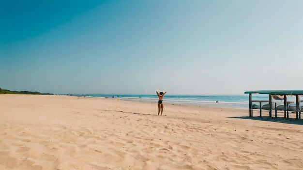 een vrouw staat op het strand met haar armen in de lucht