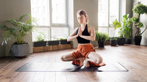 Een vrouw traint in een fitnessstudio en gebruikt een mat voor gymnastiek en lichaamsstrekkingen