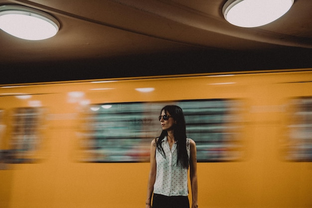 Foto een vrouw wacht op de gele trein.