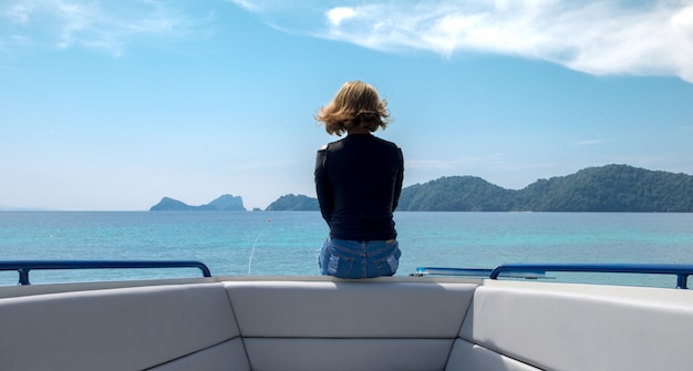 Foto een vrouw zit eenzaam op boot kijken naar de horizon