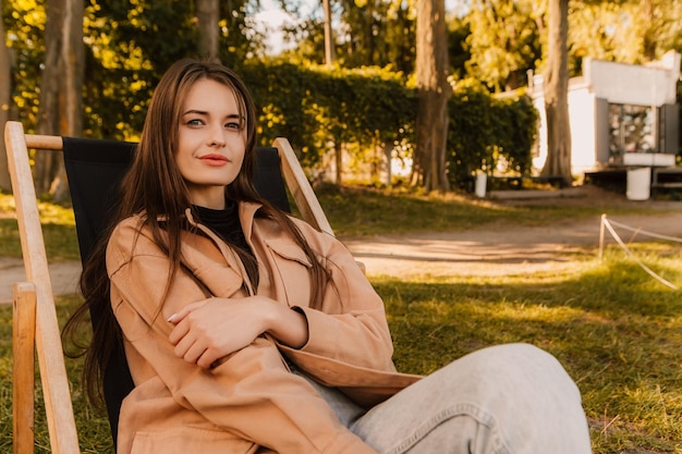 Een vrouw zit in een stoel in een park