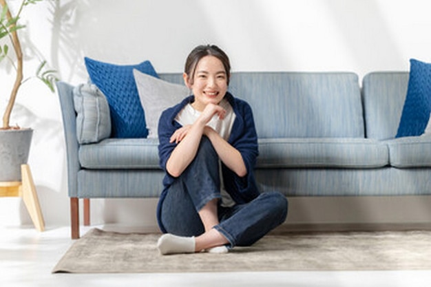 een vrouw zit op een bank met een blauw kussen