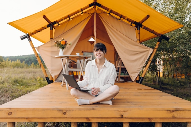 een vrouw zit op een houten platform met een laptop