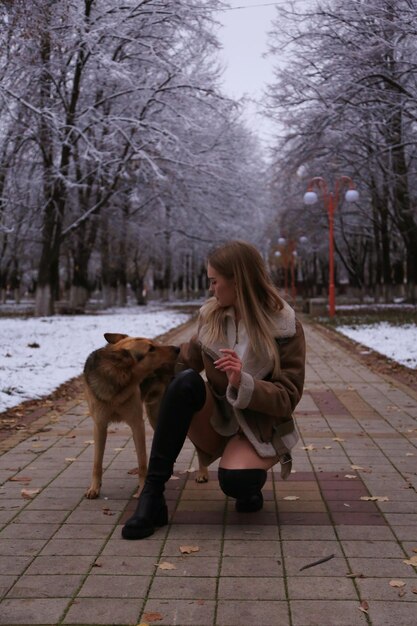 een vrouw zit op een stoep met een hond