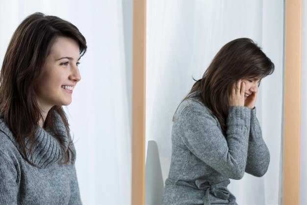 Een vrouw zit voor een raam en de andere vrouw lacht.