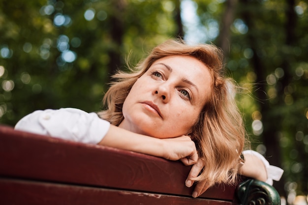 Een vrouw zittend op een bankje in het park