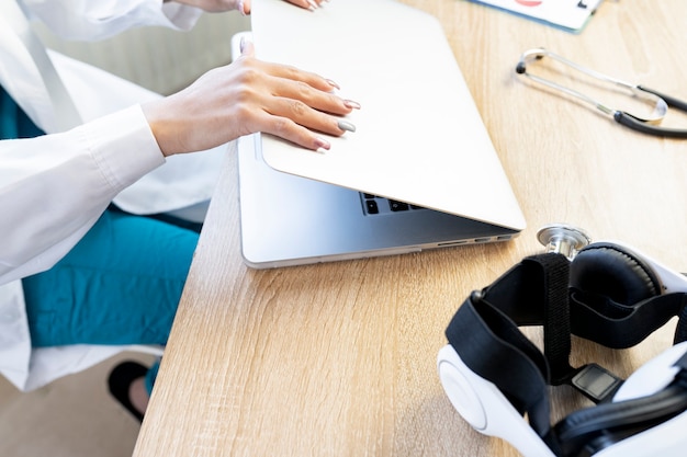 Een vrouwelijke arts die haar laptop aanzet om aan het werk te gaan
