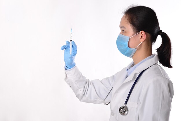 Een vrouwelijke arts houdt een spuit voor de afdeling