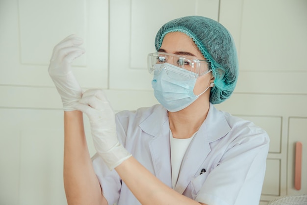 Een vrouwelijke arts trekt een handschoen aan voor de operatie